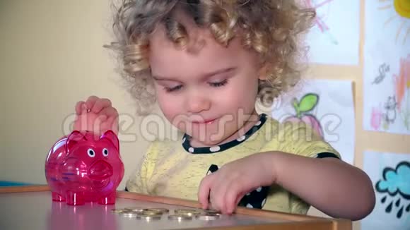 可爱的小孩在存钱罐里存钱视频的预览图