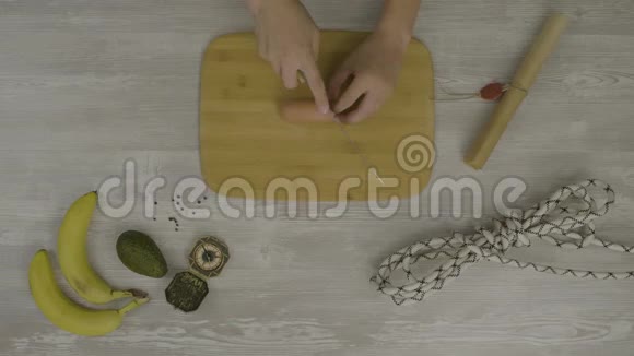 人手在木板上用刀切香肠桌子上有很多剪刀一把刀一把视频的预览图