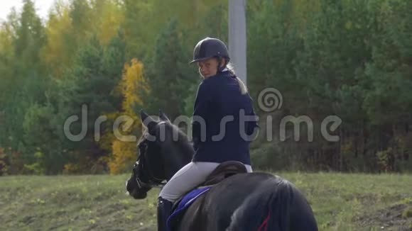 一位骑在马上的漂亮女骑师的肖像在比赛之间休息视频的预览图