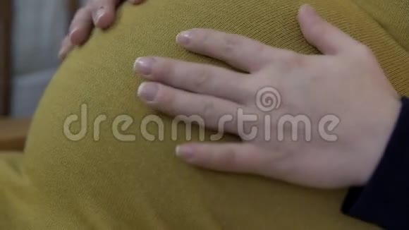 孕妇抚摸她怀孕的肚子视频的预览图