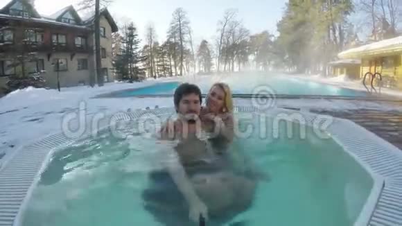 一对年轻夫妇在户外的热水浴缸里享受冬季自拍视频的预览图