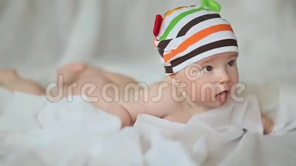 有趣的四个月大的婴儿躺在他的肚子和微笑视频的预览图