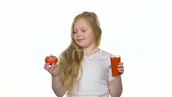 小女孩喝番茄汁舔嘴唇白色背景视频的预览图