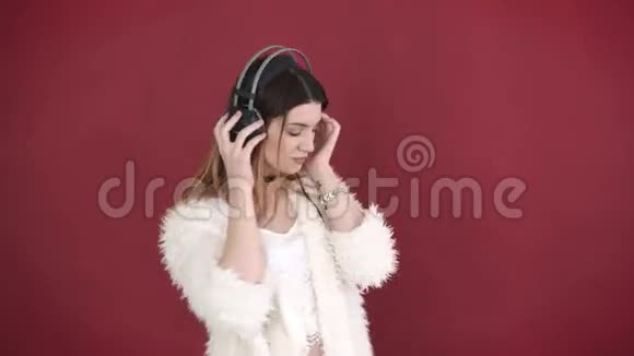 可爱的女孩用耳机听音乐视频的预览图