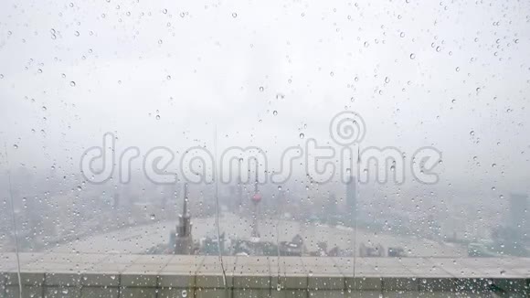 夏季雨水滴落在窗户玻璃上超慢动作大雨落在上海外滩地标背景下视频的预览图
