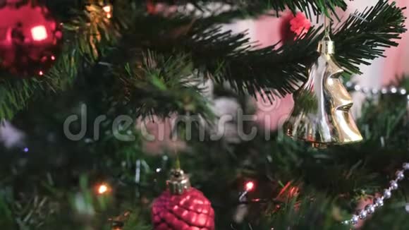 圣诞树树枝上的红色闪亮的球和金色玩具圣诞树上有灯光的圣诞花环视频的预览图