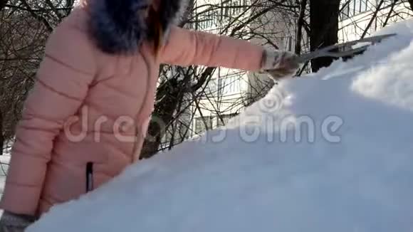 一个年轻女人从车里擦雪的冬天画像美丽的金发模特女孩笑着兴高采烈地打扫卫生视频的预览图