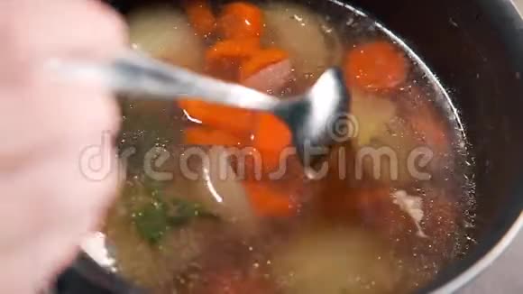 厨师用胡萝卜洋葱和香料煮蔬菜汤慢动作烹饪视频的预览图