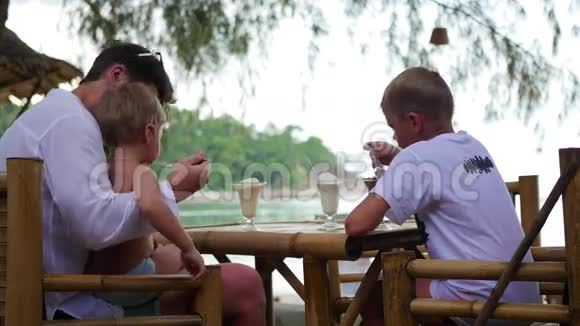 一家人在海滩的咖啡馆里吃冰淇淋视频的预览图