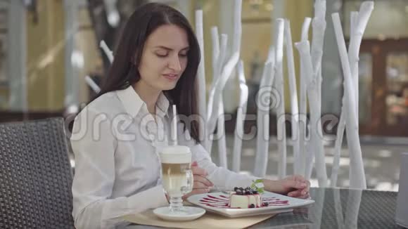 阳光明媚的一天餐厅里漂亮的黑发商务女士视频的预览图