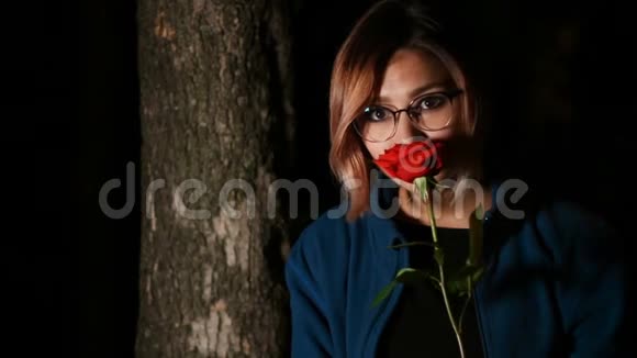 一位美丽的年轻女子带着红玫瑰视频的预览图