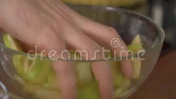手把苹果切片混合在一个碗里健康饮食烹饪素食节食和人的观念视频的预览图