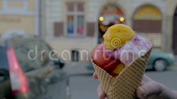 慢镜头近距离观看女人开始吃冰淇淋球背景是无重点的城市景观布拉格视频的预览图