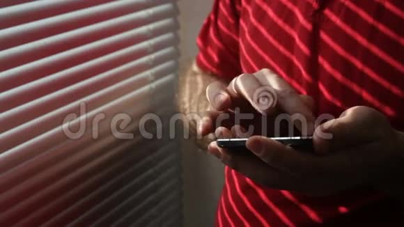在窗户附近用手机特写一个商人的手视频的预览图