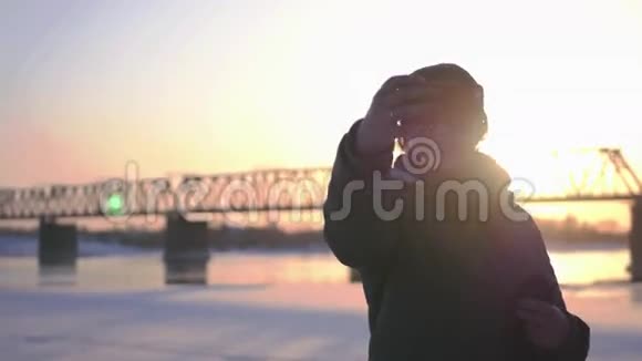 一个漂亮的女孩在日落背景和一座有铁路的桥上自拍4k视频的预览图