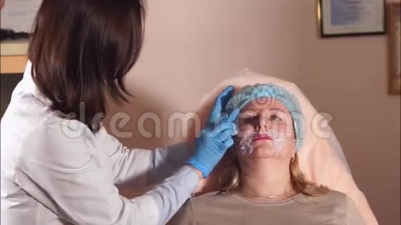美容师为一名中年妇女的面部做进一步的清洁视频的预览图