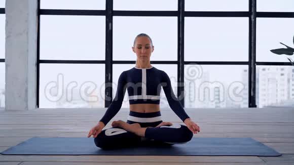 室内瑜伽体育娱乐美丽的年轻女子手里拿着泥摆着冥想的姿势个人运动视频的预览图