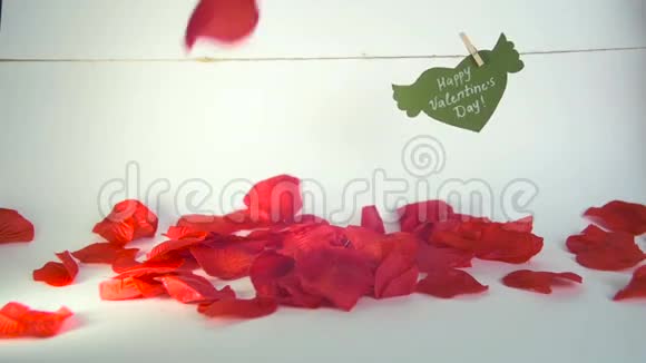 情人节概念绿色的纸心有翅膀和祝贺用绳子上的衣夹和红色的花瓣固定视频的预览图