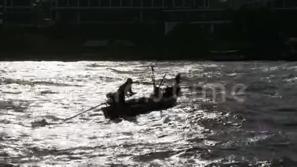 一艘小木渔船的剪影渔民们在海边活动泰国亚洲视频的预览图