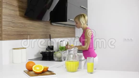 女人在现代厨房里做饭跳舞听视频的预览图