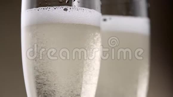 装满了两杯香槟嘶嘶声和泡沫白色气泡关门视频的预览图