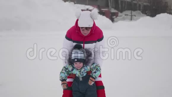 小孩子溜冰的第一步妈妈教滑冰把孩子抱在冰上积极的生活方式视频的预览图