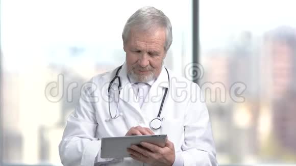 开朗的资深医生使用数字平板视频的预览图