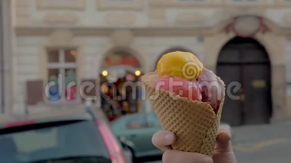 慢动作近距离观看行走的女人吃冰淇淋球背景是无重点的城市景观布拉格视频的预览图