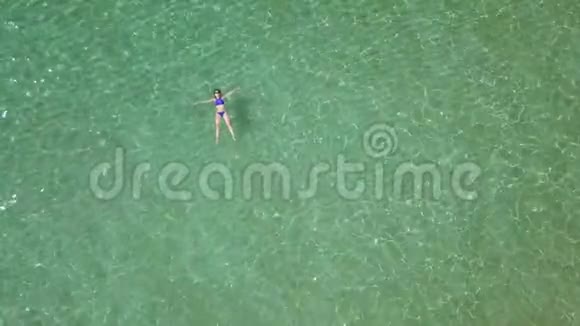 在夏天的大海里一个放松的美丽女孩躺在背上视频的预览图