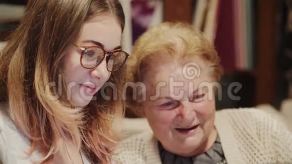 一位年轻女士帮一位年长的女士拿着笔记本电脑视频的预览图