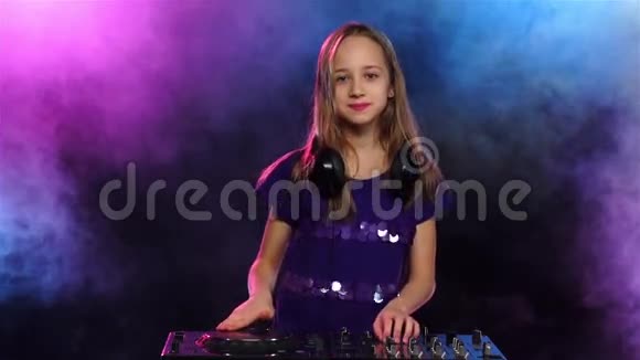 戴耳机的女孩DJ在烟雾弥漫的背景下慢动作视频的预览图