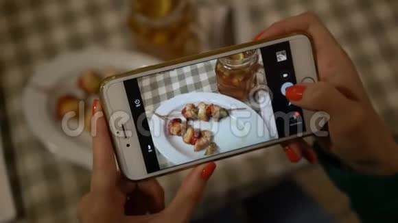 双手紧握智能手机为社交网络拍照食物视频的预览图