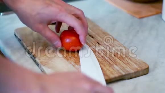 人用刀在木板上切番茄准备沙拉与西红柿视频的预览图