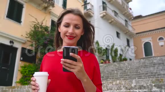 忙碌的女人站在户外的楼梯上用智能手机说话视频的预览图