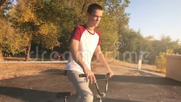 在阳光明媚的公园里极端的BMX骑自行车和跳跃兔子跳跃技巧在夏天酷年轻的宝马骑车师做奥利奇视频的预览图