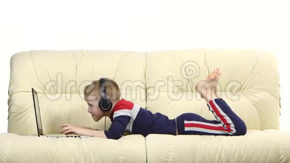 戴着耳机在沙发上玩电脑游戏的青少年视频的预览图