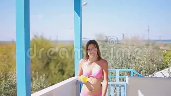 穿着泳装的苗条女士沿着城外的夏季露台视频的预览图