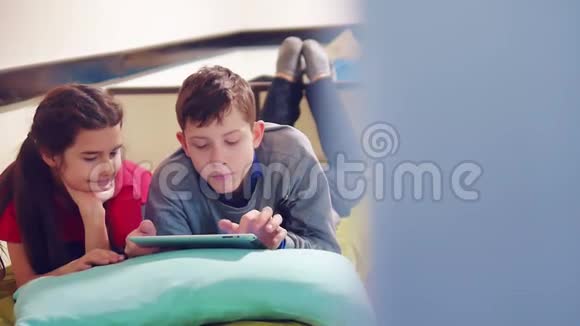 小男孩和小女孩在玩狗在平板上躺在床上青少年社会媒体生活方式视频的预览图