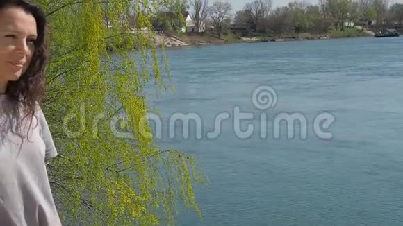 河边的年轻女子在水中长着头发的女孩春天阳光明媚的一天视频的预览图