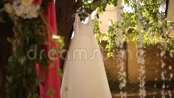 婚礼婚纱挂在一棵树上的乡村风格的婚礼带有粉红色花束花环和乡村装饰视频的预览图