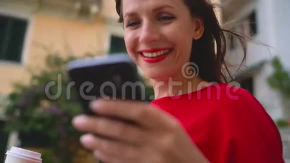 幸福的女人站在户外的楼梯上在智能手机上聊天视频的预览图