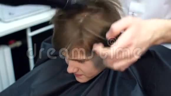 男理发师烘干一个小男孩的头发视频的预览图