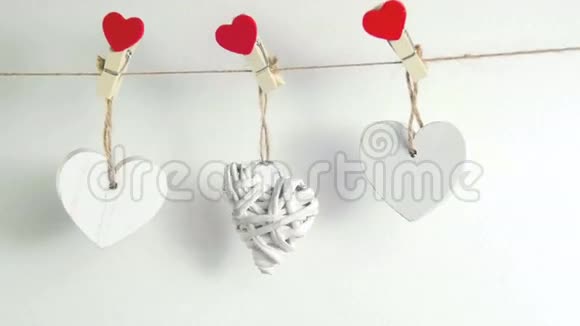 情人节概念白色的木制心固定在白色背景的绳子上视频的预览图