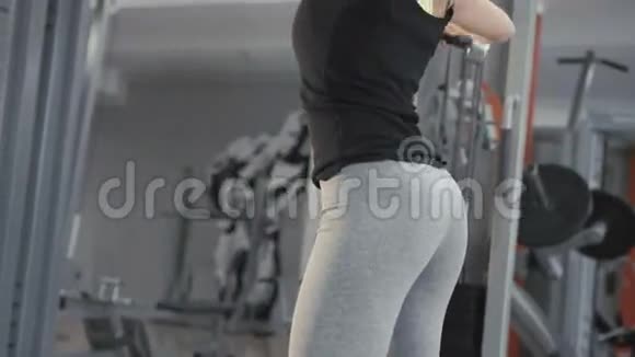 漂亮的女孩在健身房锻炼用哑铃锻炼肌肉4K后回来视频的预览图