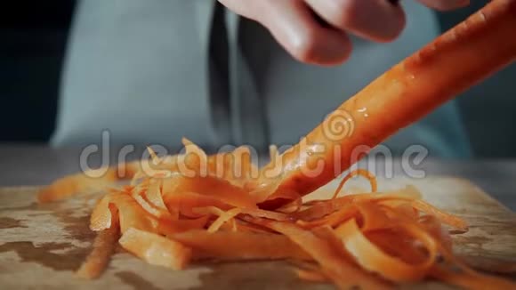 家庭主妇用胡萝卜剥素菜蔬菜沙拉在家做饭视频的预览图