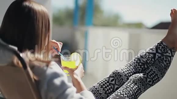 女孩坐在阳台上手里拿着柠檬鸡尾酒视频的预览图