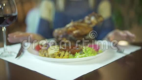 靠近蔬菜盘上巨大的烤肉女人的手在桌子上轻敲手指等待着吃视频的预览图