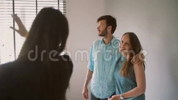 一对夫妇正在听一个女人站在镜头前移动她的手慢点斯泰迪达姆视频的预览图