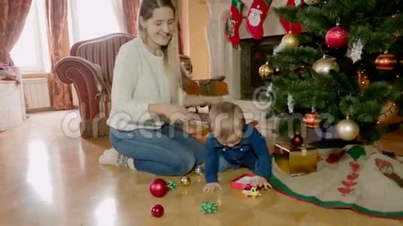 一位年轻女子和她的小儿子一起装饰圣诞树视频的预览图
