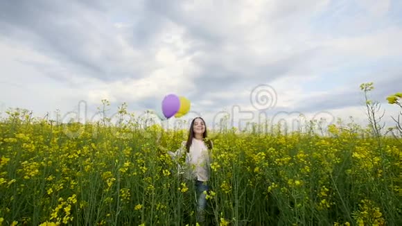快乐的女孩带着气球在麦田里散步视频的预览图